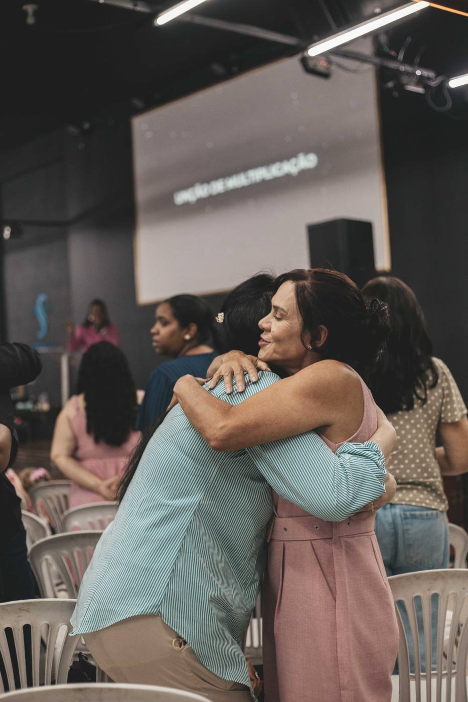 Duas mulheres se abraçando durante o culto